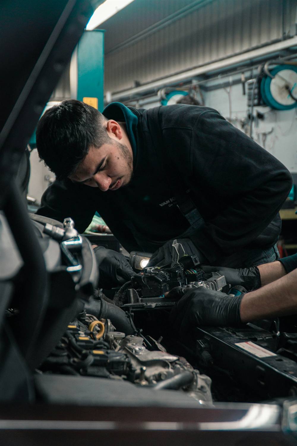 Technician in a dark uniform working on an engine
